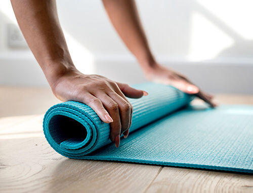 Women's hands on yoga mat