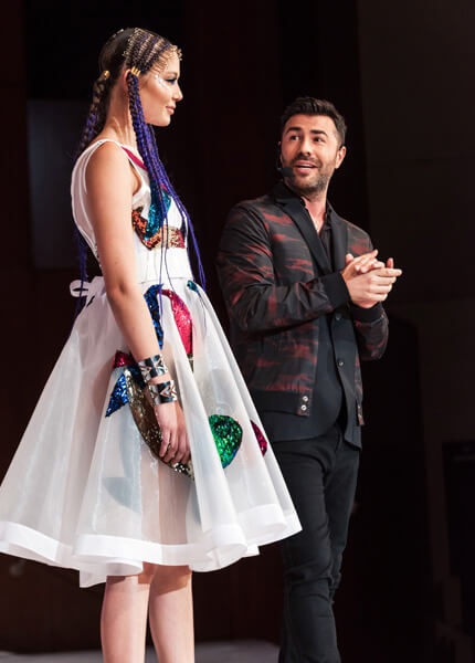 Richard Mannah on stage with model showing her hairstyle