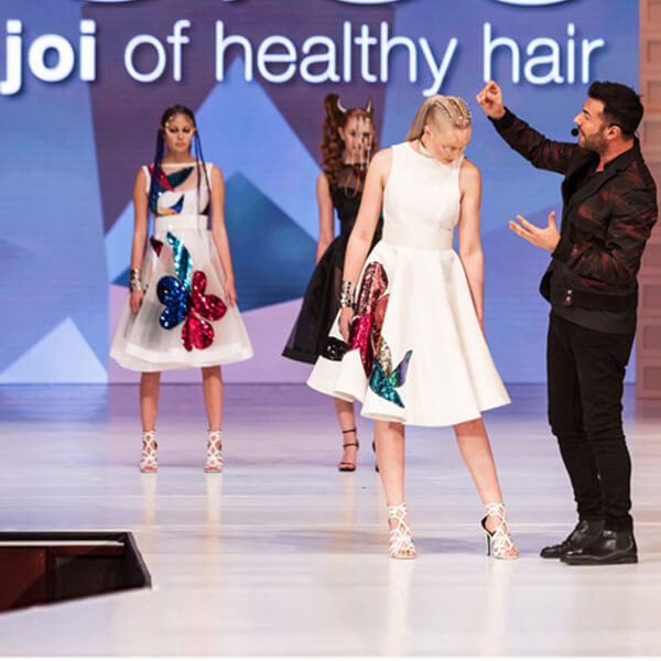 Richard Mannah on stage with model showing her hairstyle