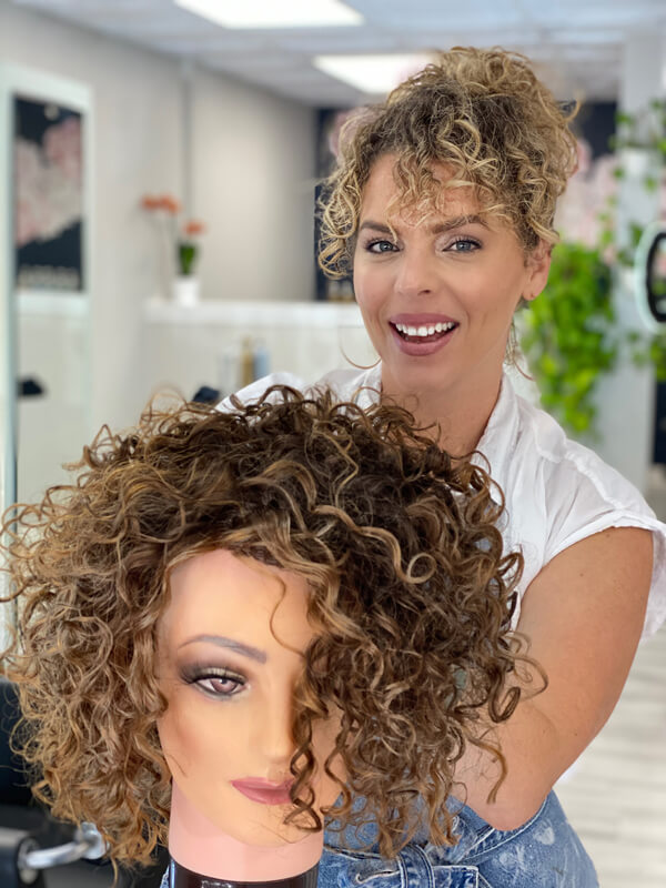 Hairdresser with styled mannequin head