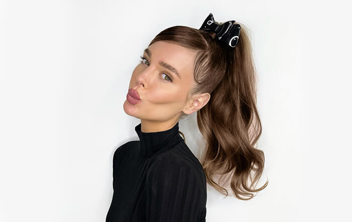 Brunette female with high ponytail looking at camera
