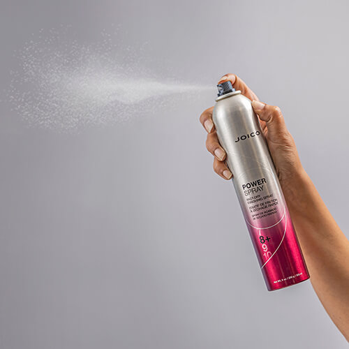 bottle of Joico Power spray being sprayed into air